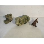 A concrete garden ornament in the form of a pig, along with boot scrapper in the form of sausage dog