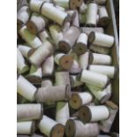 A collection of 50 wooden bobbins with metal detailing, containing cotton yarn- 7 inches long,