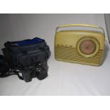 A Ricoh camera in case along with a Bush radio