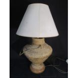 A lamp with a wicker woven base