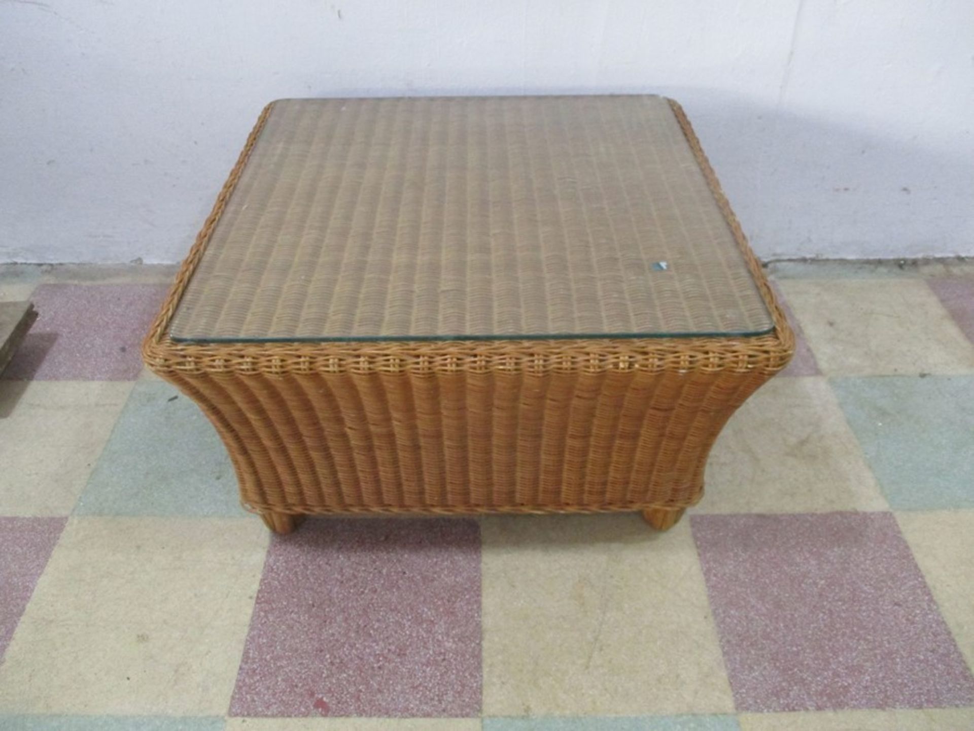 A wicker coffee table with glass top