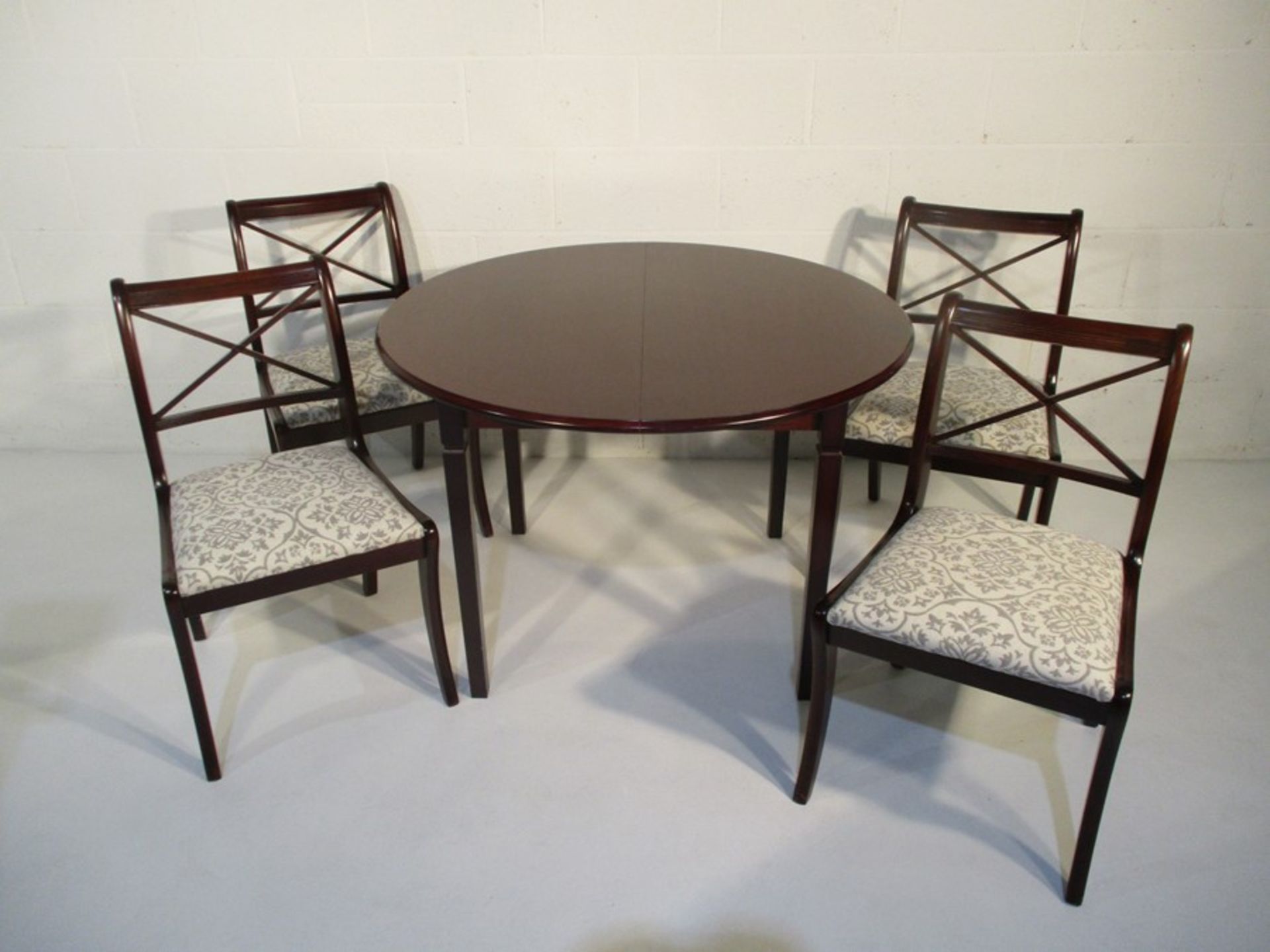 A circular extending dining table along with four matching chairs