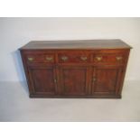 A Georgian oak dresser base with three drawers and two cupboards - height 86cm, width 156cm, depth