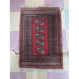 An Eastern red ground rug. Overall size 94cm x 64cm