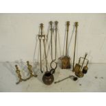 A collection of brass fireplace items including a pair of fire dogs, tongs, poker etc, along with