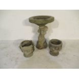 A concrete garden birdbath with cherub base, height 60cm, along with two small concrete urns