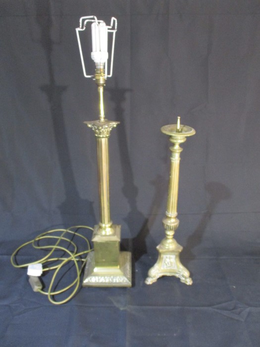 A freestanding brass lamp, along with a brass candle holder