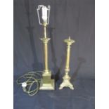 A freestanding brass lamp, along with a brass candle holder