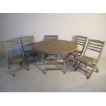 A round wooden garden table with five matching chairs