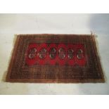 A small red ground rug - length 108cm, width 66cm