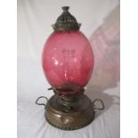A brass Thermidor Belge oil lamp with cranberry glass shade - overall height approx.55cm.