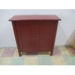 A red painted two door cupboard