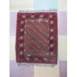 A small red ground rug. Overall size 65cm x 52cm