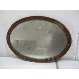 An Edwardian inlaid oval mirror. 82cm x 59cm