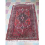 An Eastern red ground rug - Overall size approx.195cm x 128cm
