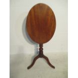 A Georgian mahogany oval tip up table on tripod base