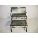 A wrought iron strapwork bench with matching table