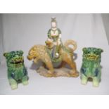 A porcelain figure of Chinese deity sat on a lion and two Foo dogs