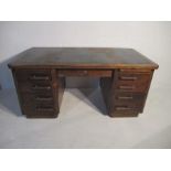 A vintage oak kneehole, twin pedestal desk with eight drawers