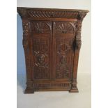 A heavily carved Jacobean style two door cupboard with single drawer over, with lion head decoration