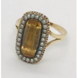 A Georgian ring with an elongated "citrine" surrounded by seed pearls set in unmarked gold