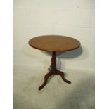 A Georgian mahogany oval tip up table on tripod base