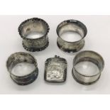 Four hallmarked silver serviette rings along with a silver vesta case (A/F)