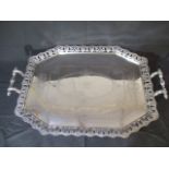 A large silver plated two handle tray with pierced decoration to rim.