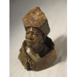 A carved hardstone bust of a man signed to reverse Nicholas Tandi with unpolished base and hat, 40