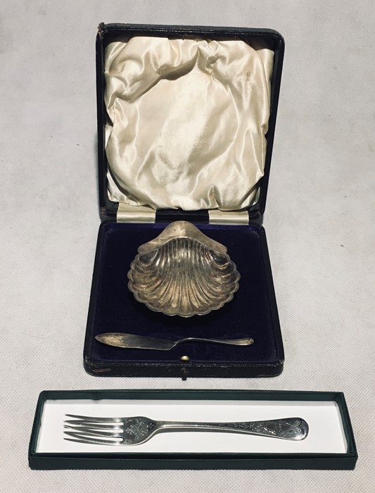 A cased silver butter dish in the form of a shell with mismatched silver knife along with an early