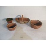 A terracotta pot in the form of a carry basket, along with three terracotta garden pots of various