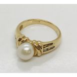 A 9ct gold dress ring set with a single pearl and diamonds to shoulder