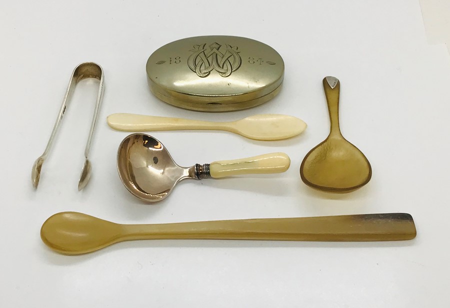 A pair of hallmarked silver sugar tongs, an SCM snuff box dated 1884, horn spoons etc