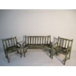 A well weathered wooden garden bench with two matching chairs