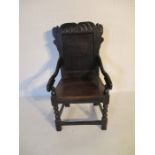 A 17th century Wainscott chair, plain panelled back with carved decoration above