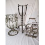 A decorative wrought iron stand with glass vase, along with a stand and metal bottle carrier