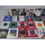 A collection of 7" vinyl records including The Beatles, Elvis Presley, David Bowie, Jefferson