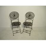 A pair of wrought iron folding garden chairs