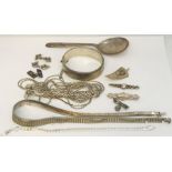 A collection of hallmarked silver items including a hinged bracelet, spoon, various necklaces etc.