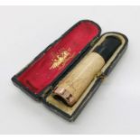 A cased cheroot holder with rose gold coloured band