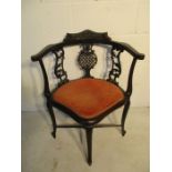 A carved corner chair with pierced decoration