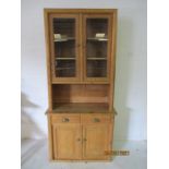 A pine dresser with glazed doors above