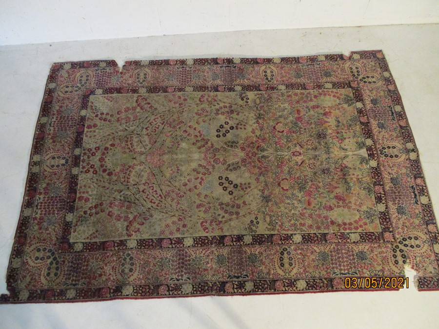A red ground rug with floral decoration, 7 ft 2" x 4 ft 9 "- some damage to edges