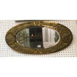 An unsigned arts and crafts oval mirror with an embossed celtic design possibly Glasgow school.