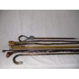 A collection of walking sticks etc. including silver topped versions