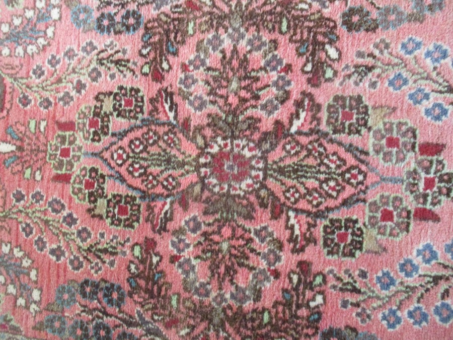 A Persian red ground rug - overall size 110cm x 70cm - Image 4 of 8