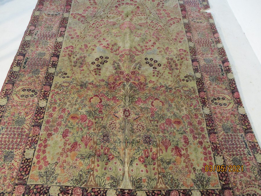 A red ground rug with floral decoration, 7 ft 2" x 4 ft 9 "- some damage to edges - Image 2 of 8