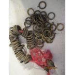 A collection of antique brass curtain rings and other metalware