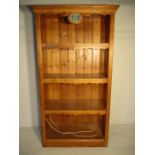 A large pine display unit with three shelves with light fitting and Portmeirion advertising plaque