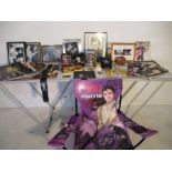 A collection of Elvis memorabilia including posters, prints, mouse mat, guitar strap, a coat hanger,